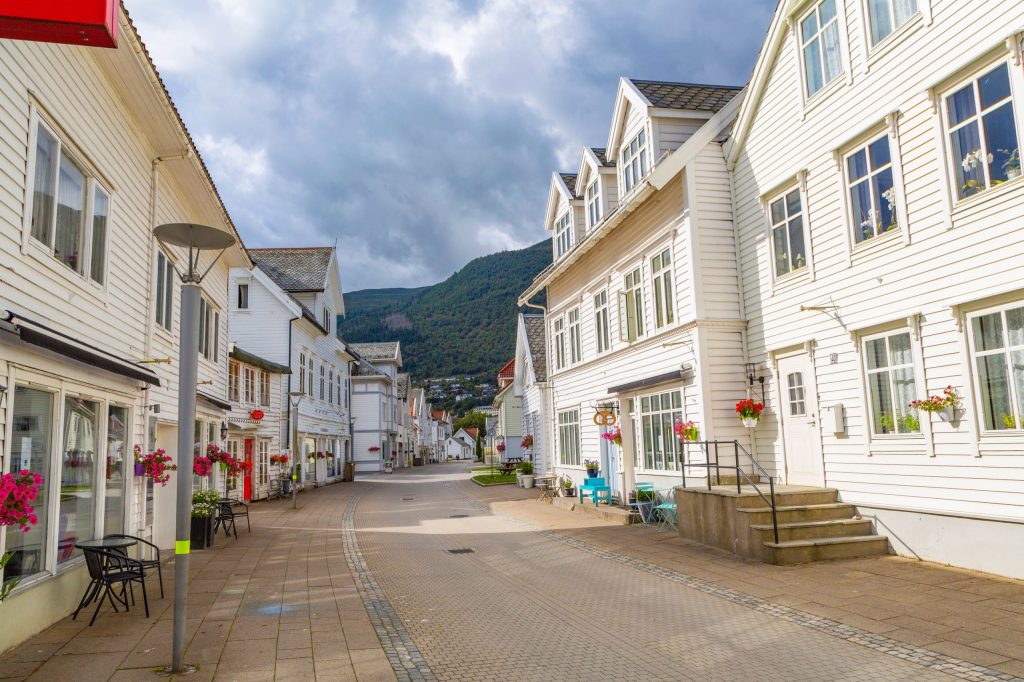 Charming street with white wooden houses and flowers.